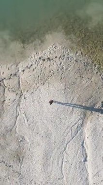 Kanalizasyonlu bir göletin kıyısında duran bir adam kuraklık tehlikesini seyrediyor.