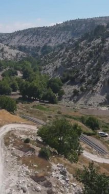 Dolambaçlı toprak yolda yürüyen adam balık çiftliğine doğru ilerliyor. Drone ile hava görüntüsü