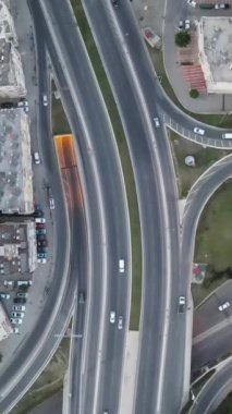 Araçlar kavşaktan geçiyor ve binalar üzerinde hareket eden bir görüntü binalar arasındaki kavşak noktalarından gelen trafik