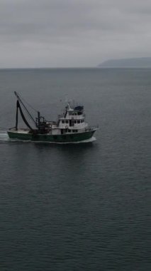 Images of boats fishing in the sea in cloudy weather, images of fishing boats fishing in the sea in closed weather around natural beauties