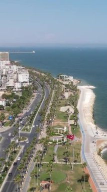 Harika bir sahil şeridinde araçların ve deniz manzarasının hareketleriyle drone görüntüsü