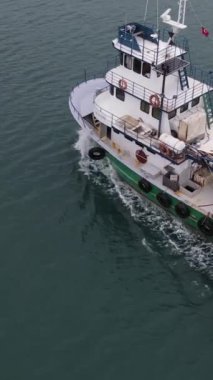 Drone footage of white fishing boat in the middle of the sea, fishing with nets, fishing seafood, white boat in the lake