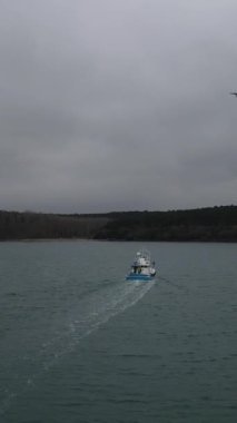 Images of boats fishing in the sea in cloudy weather, images of fishing boats fishing in the sea in closed weather around natural beauties