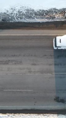 Karlı yoldan geçen kargoyu taşıyan kamyonun görüntüsü, kışın karlı yolda giden kamyonun görüntüsü.