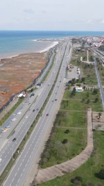 Aerial drone view of the coastal city of Trabzon, the city located on the coastline, the blocks of apartments facing the sea, mountains behind it and the city overlooking the black sea
