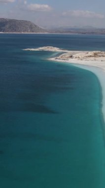The view of Salda Lake is famous as a crater lake against the mountain, drone view of Salda Lake with its white sandy beach and turquoise waters, salda lake region is surrounded mountain