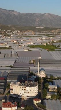 Camdan yapılmış sera şehri, tarım şehrinin en üst görüntüsü, seralarda ekinlerini yetiştiren bir şehir insansız hava aracı tarafından çekiliyor..