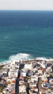 Drone view of the magnificent seaside city, the seaside where the foamy waves hit the shore, the view of the city on the TRNC island