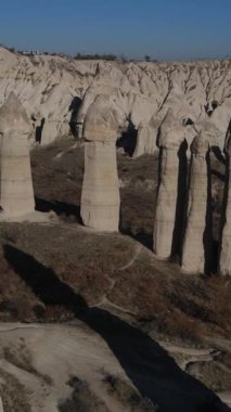 Cappadocia Türkiye 'de peri bacaları olarak bilinen doğal taşlardan oluşan turistik bir yerin havadan görünüşü, yükselen kaya oluşumları her gün batımında renk değiştiriyor.
