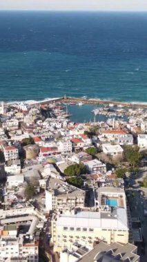 Drone view of the magnificent seaside city, the seaside where the foamy waves hit the shore, the castle of girne near by the sea in cyprus