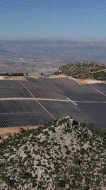 Solar energy panels installed on the forest land, drone view of the solar energy system in the middle of the land, generating electrical energy for large glass panels