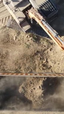 Kum ocağında çalışan kazıcı ve kamyon, kazıcı bir çöp kamyonuna kum yüklüyor, bahçenin yanında çalışan inşaat makineleri, İHA atışı.