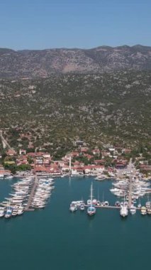 Dağın eteğinde inşa edilen zengin tatil köyünün insansız hava aracı görüntüsü, Akdeniz 'e demirlemiş yatlar ve tatil köyü.