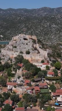 Simena 'nın antik harabelerinin drone görüntüsü, dağın tepesindeki gözetleme kulesi, taşlardan yapılmış antik kalıntılar.