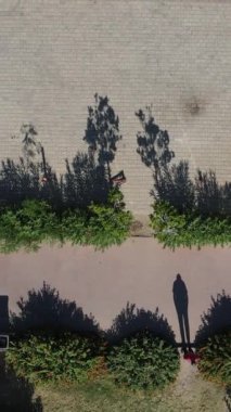 İnsanların gölgeleri karavanlarını park eder, park edilmiş portatif evlerin duraklarında durur, yaz günlerinde insanların dışarıdaki eğlencelerini uzaktan izlerler.