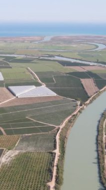 Türkiye 'deki geniş deltanın hava aracı görüntüsü, nehir araziyi besliyor ve çevresindeki araziler, nehir kenarındaki ekili yeşil alanlar,
