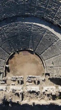 Antik tiyatro, insansız hava aracı manzarası antik tiyatronun üzerinde yükseliyor, büyük çoğunluğu ayakta kalan bir tiyatro manzarası, Antalya, Türkiye