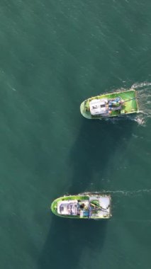 Aerial drone view of the white ship fishing in the lake, fishermen in the waters when the season starts, fishermen hunting in the middle of the sea