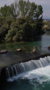 Drone şelalesi manzarası, yeşil ağaçlarla kaplı nehrin üzerindeki şelale dökülen köpükleri oluşturur, harika bir manzara sunan şelale havadan görülür. Manavgat, Türkiye