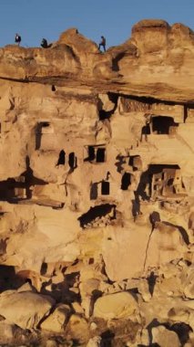 Cappadocia Türkiye 'de peri bacaları olarak bilinen doğal taşlardan oluşan turistik bir yerin havadan görünüşü, yükselen kaya oluşumları her gün batımında renk değiştiriyor.