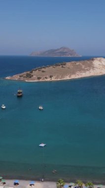 Akdeniz adası, harika bir körfezde yüzen insanlar gezi tekneleriyle seyahat ediyor güzel günün tadını çıkarıyorlar adalara karşı harika bir manzara