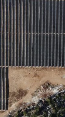 Solar energy panels installed on the forest land, drone view of the solar energy system in the middle of the land, generating electrical energy for large glass panels
