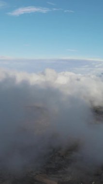 Bulutlu bir gökyüzünün altındaki hava aracı görüntüsü, sisli bir dağ zirvesi, yüksek kayaları, ormanı ve gökyüzü olan güzel bir manzara.