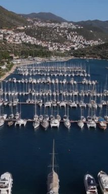 Dağın eteğindeki zengin marina yerleşkesi, körfezdeki sahil şehrinin insansız hava aracı manzarası.