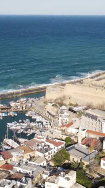 Drone view of the historical Kyrenia castle built by the sea, the walls of the historical castle made of stone, the historical beauties of the city of Kyrenia