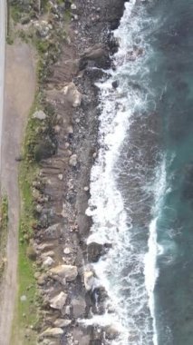 Drone view of the crystal clear sea waters of Kyrenia, turquoise color of the open sea, rocks and the natural beauty of cyprus with waves crashing on the beach