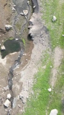 Ormandaki hava yatağı, taşların arasından akan küçük orman deresi, içinden suyla akan küçük derenin drone görüntüsü, ormandaki su yolu.