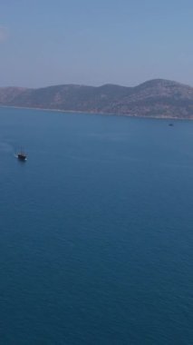 Ada turizmi, açık denizde gezinen bir tekne ve mavi sularda eğlenen büyük bir ada.