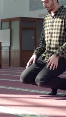 İslam 'a inanan genç adam mescitte namaz kılarken, alnı secde eder.