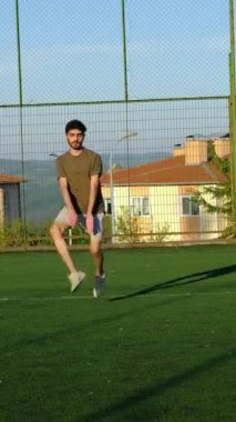 Genç bir adam elleri bacaklarının arasında halıda koşar ve zıplar. Antrenmandan önce ısınma turu bitmiş olmalı.