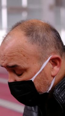 Maskeli yaşlı bir adam, elini kaldırdı ve camiden namaz kıldı. Mescid-i Haram 'a gelip Allah' a dua ettiler.
