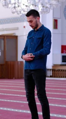 Mescid-i Haram 'da namaz kılan müslüman bir gencin farklı bir açıdan çekimi. İslam' a inanan genç adam Mescidi Haram 'a dua ediyor.