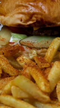 Patates kızartmasıyla dolu hamburger servis tabağı, lezzetli hamburger menüsü resmi, beyaz servis tabağında kızarmış fast food menüsü.