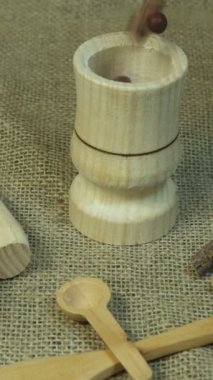 Slow motion advertisement of spices poured into wooden mortar, nature products theme on wicker serving table, thematic nature products with wooden spoons and seeds