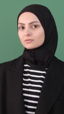 Müslüman genç kadın başıyla işaret et, tesettürcü kız yeşil ekranın önüne işaret et, kadın ifadesi cidden