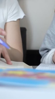 Yakın çekim okuyan öğrencilerin parmak resimleri, öğrencilerin kalemlerle haritayı çizmeleri ve üzerine not almaları, coğrafya okuyan öğrencilerin yakın plan fotoğrafları.