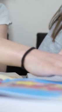 Coğrafya okuyan iki genç kızın yakın çekimi, haritalar üzerine ev ödevi, ülke haritaları üzerine özel dersler, harita ve kalem kullanarak ödev yapan iki kız.