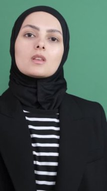 Müslüman genç kız parmağını sallıyor, genç kız ifadesi kroma anahtarının önünde ciddi olarak, kızgın jestler yapıyor.
