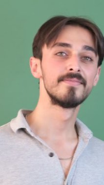 Kafası sallanan sakallı adam, elleri beyaz genç adam, izole edilmiş yeşil arka plan önünde imza atalım.