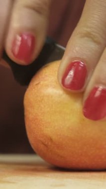 Armudu bıçakla keserken yakın plan görüntü, armut meyvesini ikiye bölen bıçak tutan kadın, taze tematik meyve görüntüsü.