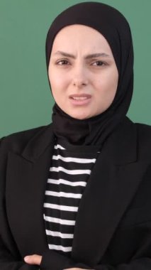 Karnı ağrıyan bir kadın, aniden hasta bir kadın izole edilmiş yeşil bir altyapının önünde, Müslüman kız ifadesi hüzünlü.