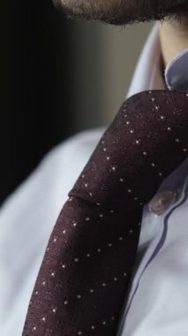 İş adamı kravatıyla oynamaktan yoruldu. Takım elbiseli adam kravatını gevşetmeye çalışıyor. Kravatını gevşetiyor.