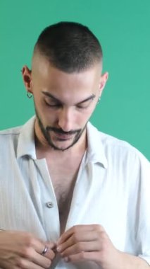 Adam sıcaktan soyuluyor, erkek model aşırı sıcakta terliyor, erkek model yeşil ekranın önünde sıcaktan, duygulardan ve yüz ifadelerinden boğuluyor.