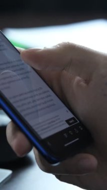 Telefondan haber okuma, telefon ekranından belge izleme, masadaki telefon ekranıyla ilgilenme.