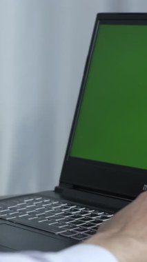 Yeşil ekran monitöründe çalışan sıradan giysili bir adam, işini bilgisayardan yürüten bir çalışan, ofiste masa başı bir çalışma ortamı.