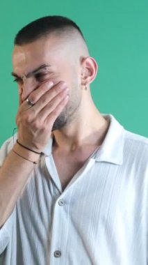 Kötü kokan bir adamın yüz ifadesi, kötü kokuyu bastıran yüz ifadeleri, yeşil ekranın önünde vücut dilini ve yüz ifadelerini gösterme.